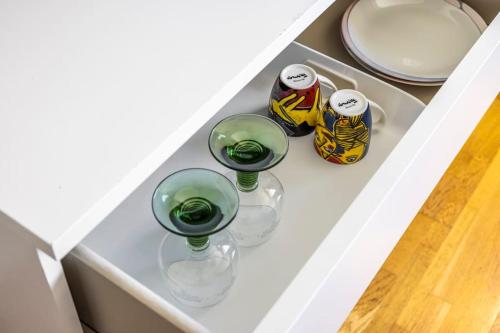 three wine glasses on a shelf in a drawer at Quiet Rum in Swedish villa in Huddinge