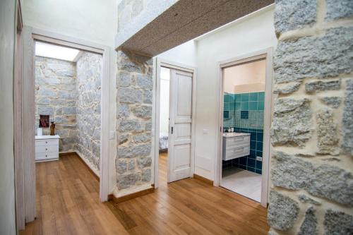 baño con pared de piedra y espejo en Villa S'Olioni, en Loceri