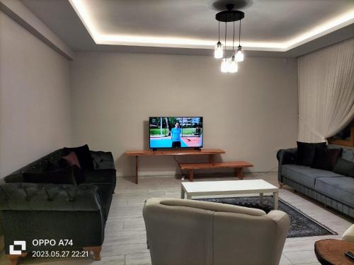 a living room with a couch and a tv at TRABZON-AKÇAABAT/MERSİN in Vartara