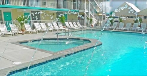 a large swimming pool with chairs in a hotel at Aqua Beach Hotel in Wildwood Crest