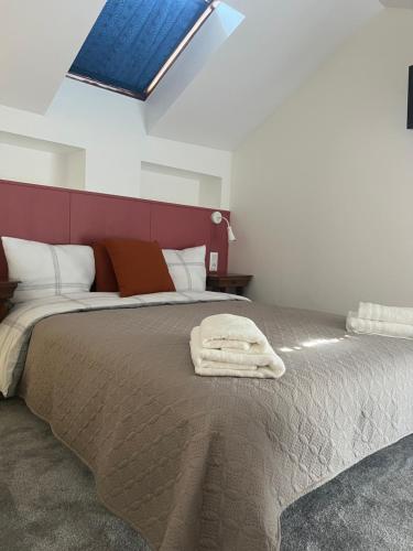 une chambre avec un grand lit avec une tête de lit rouge dans l'établissement THEIA - Limoges Centre, à Limoges