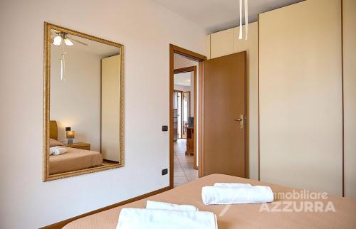 バルドリーノにあるLa Terrazza sul Lago - Immobiliare Azzurraのベッドルーム(鏡、ベッド付)