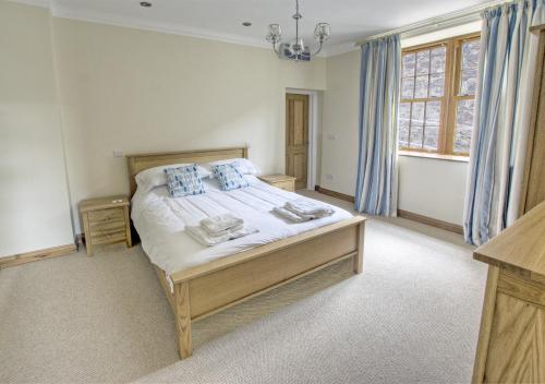 a bedroom with a large bed with blue curtains at Sovereign in Seaton