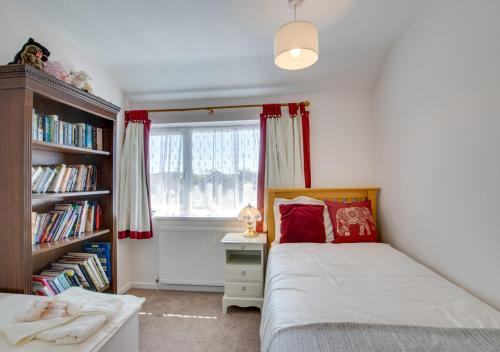 um quarto com uma cama e uma estante de livros em Puffins em Paignton