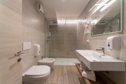 a white bathroom with a sink and a toilet at CityU - Grazioli 27 Trento Centro con parcheggio privato in Trento