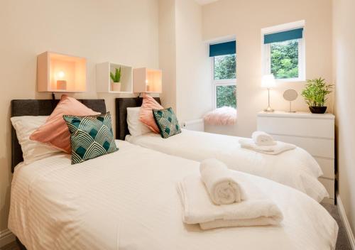 two beds in a bedroom with towels on them at The Old Drapers House in Brixham