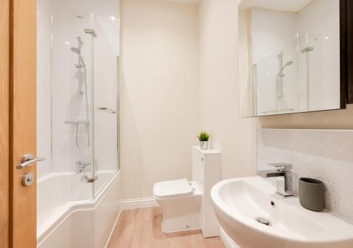 La salle de bains est pourvue d'un lavabo, de toilettes et d'une douche. dans l'établissement The Old Drapers House, à Brixham