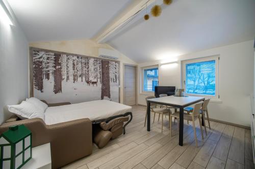 Habitación con cama, escritorio y mesa. en CityU - Grazioli 27 Trento Centro con parcheggio privato en Trento