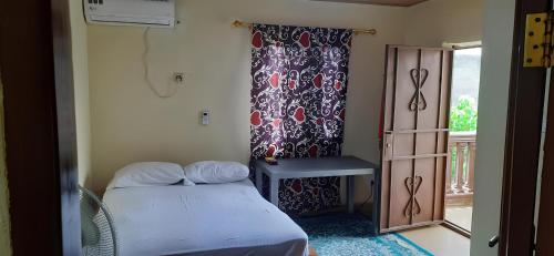 a small bedroom with a bed and a window at Yogi Home Stay Near Freetown Airport in Freetown