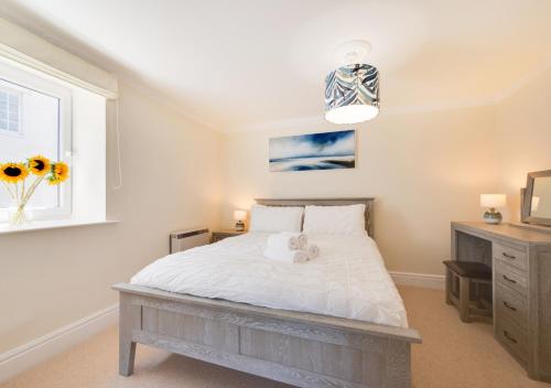 sypialnia z białym łóżkiem i oknem w obiekcie Honey Cottage Mews w mieście Torquay