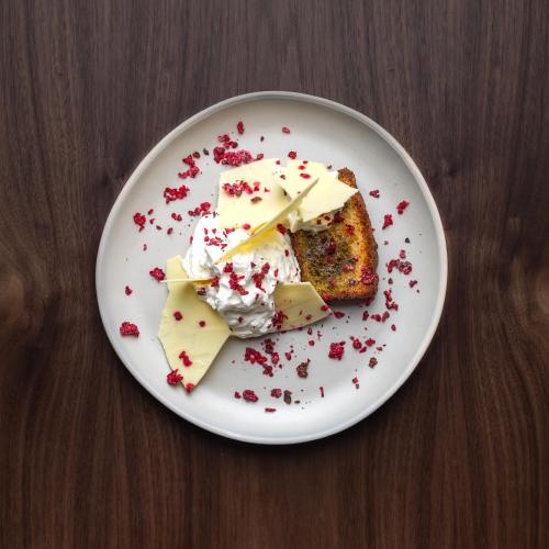 a white plate with a piece of cake and whipped cream at Château De Razay in Céré-la-Ronde