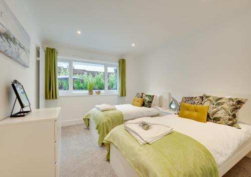 een slaapkamer met 2 bedden en een raam bij Compass Rose in Brixham