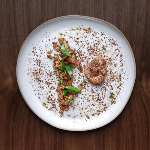 a white plate with food on a wooden table at Château De Razay in Céré-la-Ronde