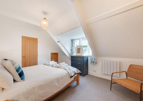 a bedroom with a bed and a chair at 2A Riverview - Top Flat in Dartmouth