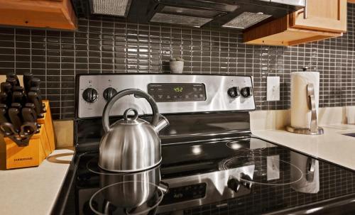 a tea kettle sitting on top of a stove in a kitchen at Placemakr Music Row - Vanderbilt in Nashville