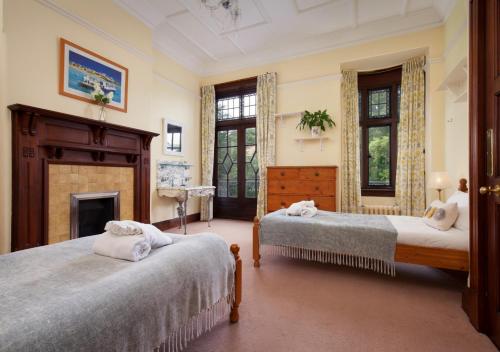 a bedroom with two beds and a fireplace at Wolborough House in Brixham