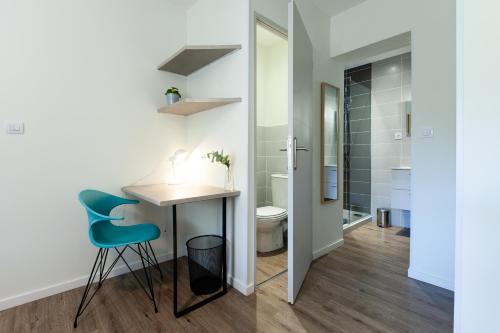 La salle de bains est pourvue d'une table, de 2 chaises et de toilettes. dans l'établissement La Villa Capuccine, à Nîmes