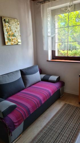 a couch sitting in a room with a window at RENESANS in Władysławowo