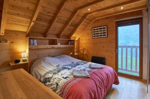 a bedroom with a bed in a wooden cabin at chalet la traverse in Allemont