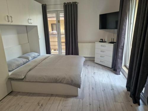 1 dormitorio con 1 cama, vestidor y TV en Cazare Andreea, en Cluj-Napoca