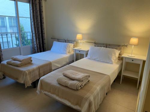 2 Betten in einem Hotelzimmer mit Handtüchern darauf in der Unterkunft Casa Sally - Mijas Golf in Mijas Costa
