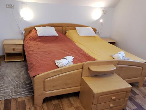 een paar bedden in een slaapkamer met handdoeken bij Berkenye Pihenőház in Sárvár
