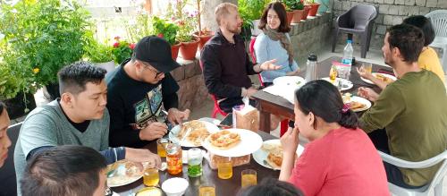 Eine Gruppe von Menschen, die an einem Tisch sitzen und Essen essen. in der Unterkunft Sukoon Turtuk Home Stay in Turtok