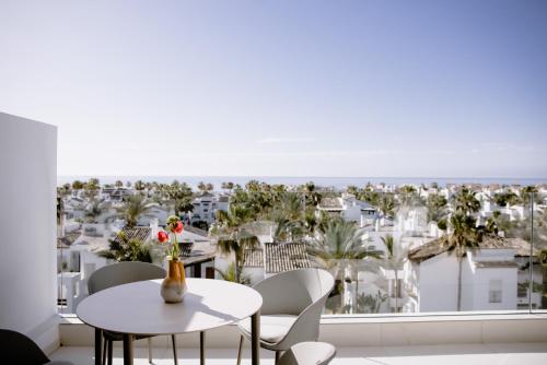 een kamer met een tafel en stoelen en uitzicht op de stad bij THE FLAG Costa del Sol Marbella, Estepona in Estepona