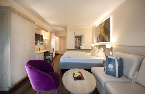 a hotel room with two beds and a couch at Vitalhotel der Parktherme - inkl Thermeneintritt & Sauna in Bad Radkersburg