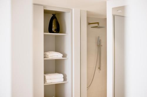 a bathroom with white shelves and a shower at THE FLAG HOTEL Marbella, Estepona Adult Recommended in Estepona