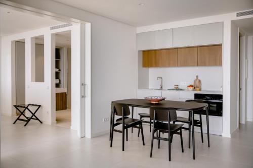 a kitchen and dining room with a black table and chairs at THE FLAG HOTEL Marbella, Estepona Adult Recommended in Estepona