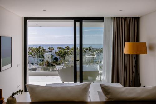 a bedroom with a bed and a large glass window at THE FLAG HOTEL Marbella, Estepona Adult Recommended in Estepona