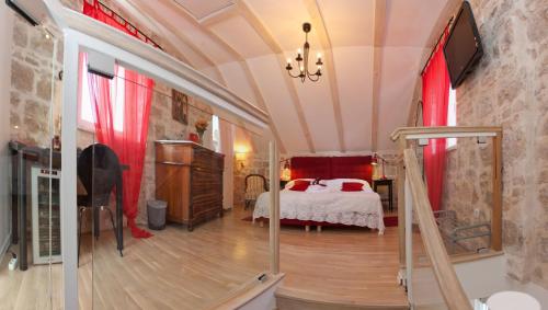 Cette chambre comprend un lit avec des rideaux rouges et une télévision. dans l'établissement Bed & Breakfast Vila Baguc, à Split