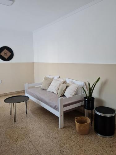 a white bed with pillows and a table in a room at BELGRANO HOME. ALQUILER TEMPORARIO EN SAN FRANCISCO in San Francisco