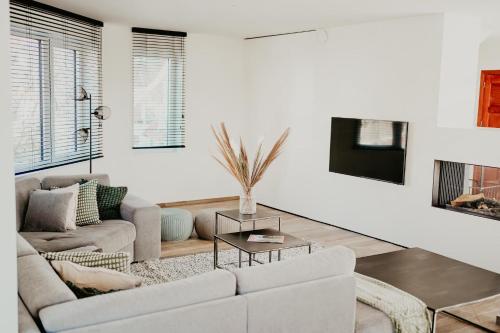 a white living room with a couch and a table at Luxurious 4BR Villa's In Knokke in Knokke-Heist