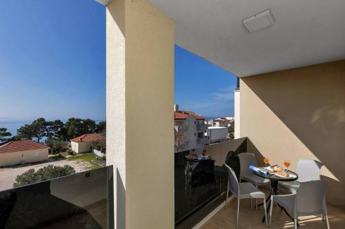 a balcony with a table and chairs and a view at Apartment Hrvoje -nur 50m bis zum Meer - Makarska Exklusiv in Promajna