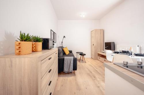 a kitchen with white walls and wooden floors and a counter top at Apartamenty Pamiątkowa 11, 2 rooms, self check in 24h in Poznań