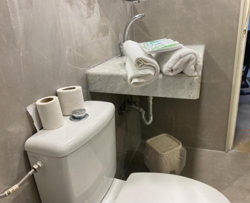 uma casa de banho com WC e toalhas numa prateleira em Apartment in Lev Jerusalem Hotel em Jerusalém