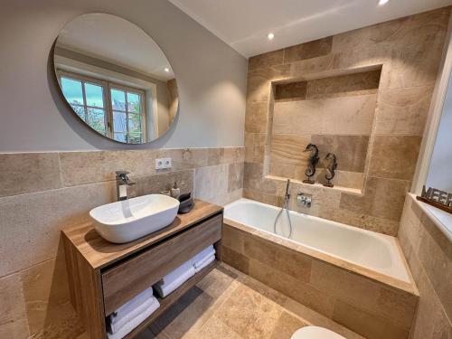 a bathroom with a sink and a tub and a mirror at Strand und Meer in List