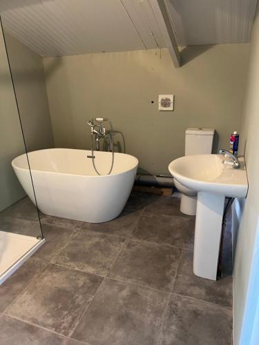 a bathroom with a tub and a sink at The Old Water Works - Flat 1 in Wadebridge