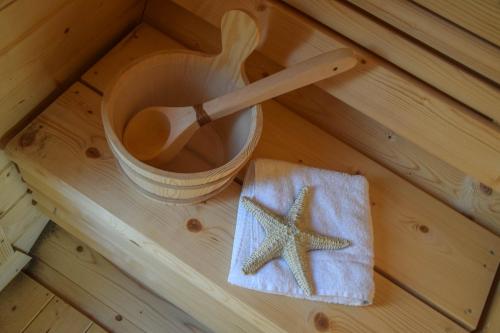 a wooden sauna with a wooden spoon and a starfish at Strand und Meer in List