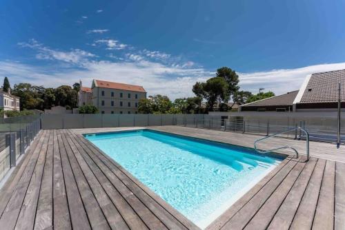 - une piscine sur une terrasse en bois à côté d'un bâtiment dans l'établissement Stylish 1BDR Apt w/Huge Balcony/Shared Roof Pool, à Cannes