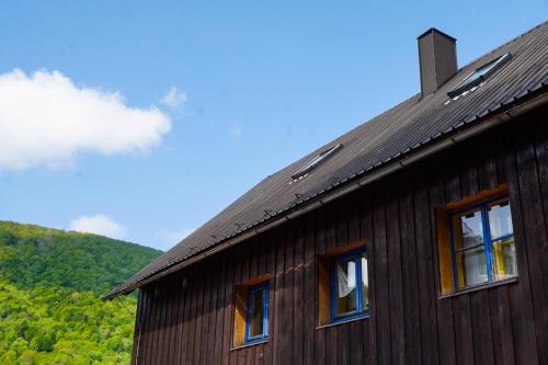Una casa con tres ventanas en el costado. en Planinarski dom ''Bijele stijene'' Mountain lodge, en Tuk Vojni