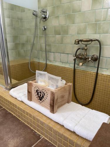 una scatola di legno seduta su un asciugamano in doccia di Antico Casale Il Sambuco a Manduria