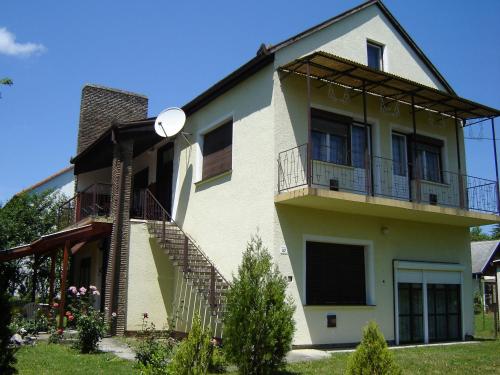 a house with a balcony and stairs on it at Mátyás király Apartman in Vonyarcvashegy