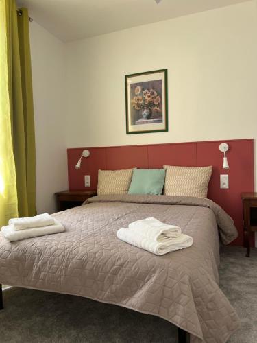 een slaapkamer met een bed met twee handdoeken erop bij THEIA Hotel & Suites - Limoges Centre in Limoges