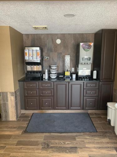 een keuken met houten kasten en een aanrechtblad bij Comfort Inn in Cornwall