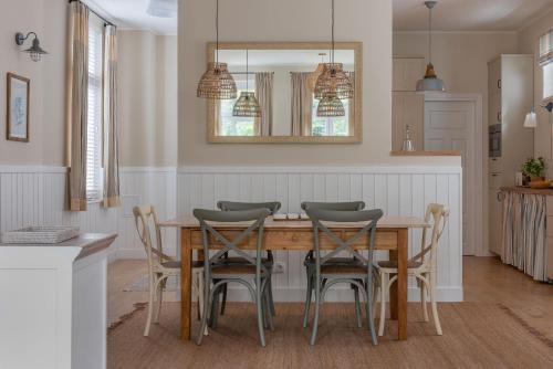 a dining room with a wooden table and chairs at Agapella Apartamenty- Sopot Cottage Ogród 400m od plaży 6 dorosłych i dzieci in Sopot