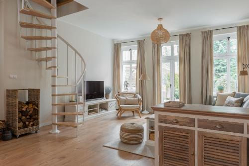 a living room with a spiral staircase and a television at Agapella Apartamenty- Sopot Cottage Ogród 400m od plaży 6 dorosłych i dzieci in Sopot