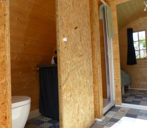 a bathroom with a toilet in a wooden cabin at B2B Campingpods Volkach in Volkach